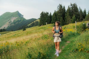 determined cheerful woman hiking in swiss alps in summer