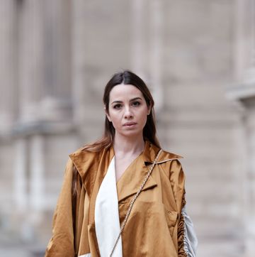 paris, france march 30 maria rosaria rizzo wears a maison bousquet brown lustrous long trench coat, white pants, a long wavy hairstyle adorned with a brown velvet hair bow by alexandre de paris, a chanel round quilted bag, during a street style fashion photo session, on march 30, 2024 in paris, france photo by edward berthelotgetty images