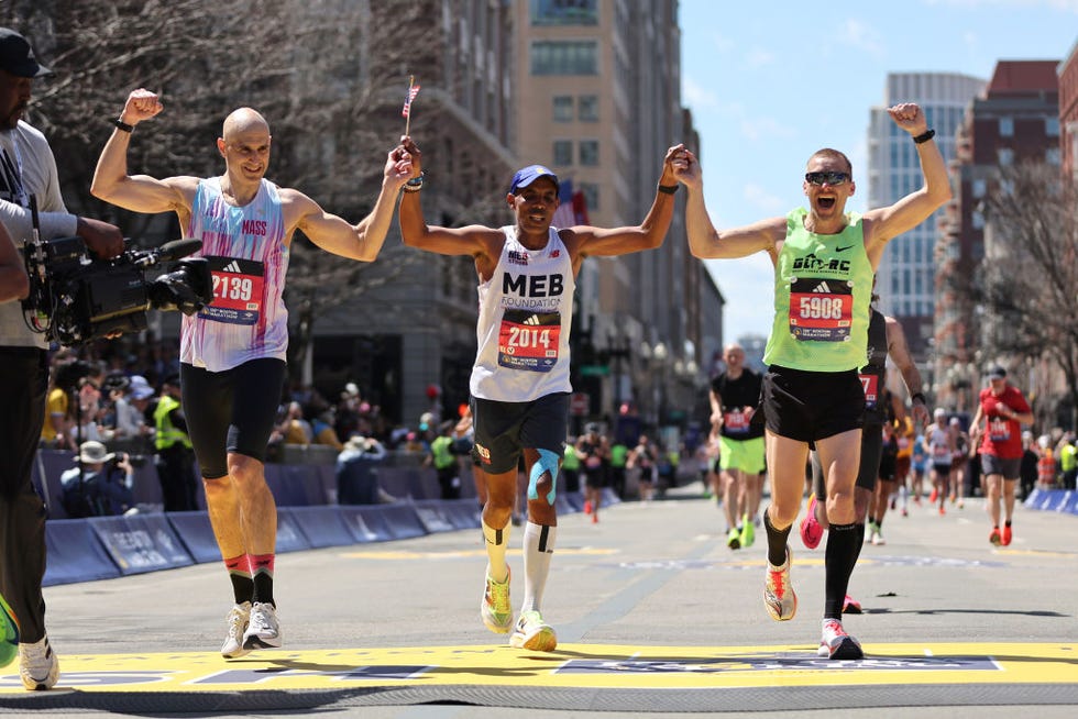 boston, massachusetts april 15 2014 boston marathon champion meb keflezighi of the united states crosses the finish line with guy gibson and immanuel wineman during the 128th boston marathon on april 15, 2024 in boston, massachusetts photo by paul rutherfordgetty images