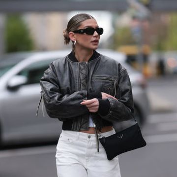 berlin, germany april 22 sophia geiss seen wearing prada black symbole sunglasses, silver earrings, uniqlo white cotton basic top, acne studios black faded cropped leather jacket, arket creamy white denim baggy jeans pants, prada black nylon mini bag and adidas x wales bonner black sneakers, on april 22, 2024 in berlin, germany photo by jeremy moellergetty images