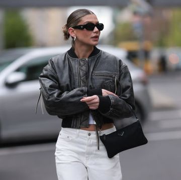 berlin, germany april 22 sophia geiss seen wearing prada black symbole sunglasses, silver earrings, uniqlo white cotton basic top, acne studios black faded cropped leather jacket, arket creamy white denim baggy jeans pants, prada black nylon mini bag and adidas x wales bonner black sneakers, on april 22, 2024 in berlin, germany photo by jeremy moellergetty images