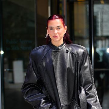 dua lipa masters the oversize trend whilst wearing an oversized leather jacket a diamond clutch bag blue jeans and black pointed heels