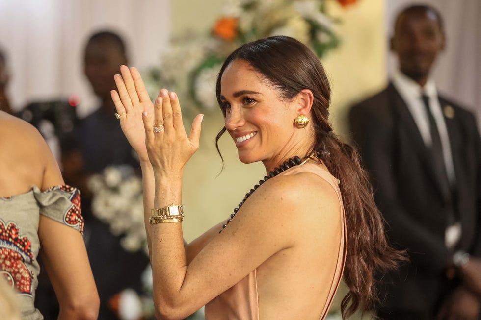 britain's meghan, duchess of sussex, gestures as she arrives with britain's prince harry unseen, duke of sussex, during their visit at the lightway academy in abuja on may 10, 2024 as they visit nigeria as part of celebrations of invictus games anniversary photo by kola sulaimon afp