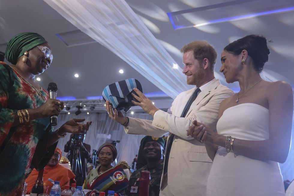 britain's prince harry 2nd l, duke of sussex, and britain's meghan r, duchess of sussex, receive a traditional outfit made in nigeria as they attend a sit out at the nigerian defence headquarters in abuja on may 11, 2024 as they visit nigeria as part of celebrations of invictus games anniversary photo by kola sulaimon  afp