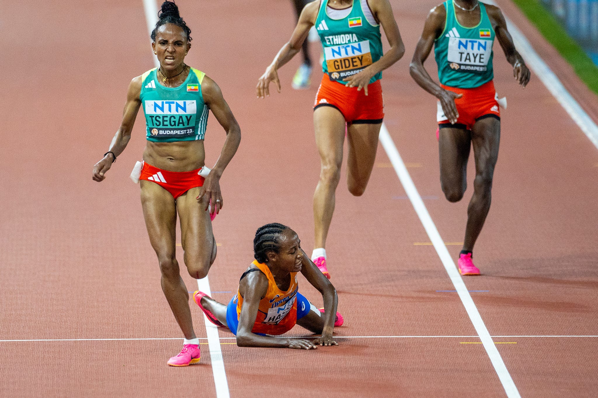 female athletes competing in a track event nearing the finish line