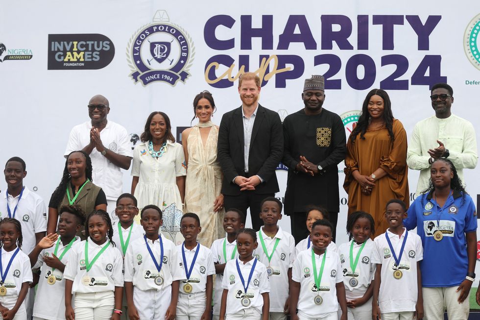 lagos polo club president bode makanjuola l, his wife moyo makanjuola 2ndl, britains meghan 3rdl, duchess of sussex, britains prince harry 4thl, duke of sussex, nigeria chief of defense staff christopher musa 3ndr, his wife lilian musa 2ndr and regional head of equity research for west africa at standard bank group, muyiwa oni r pose for a photo with children after a charity polo game at the ikoyi polo club in lagos on may 12, 2024 as they visit nigeria as part of celebrations of invictus games anniversary photo by kola sulaimon  afp photo by kola sulaimonafp via getty images