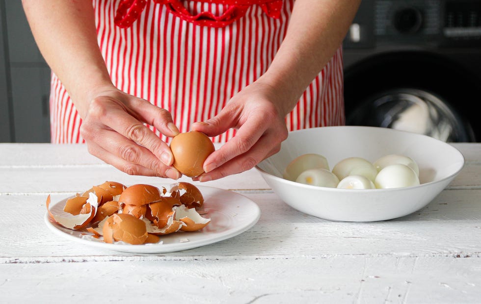 how long do hard boiled eggs last? a woman peels eggs