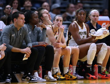 basketball players and coaching staff on the bench during a game