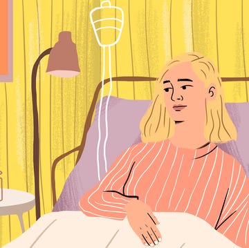 Mother visits smiling ill daughter in hospital Two women in a hospital room one sitting next to the other in a bed