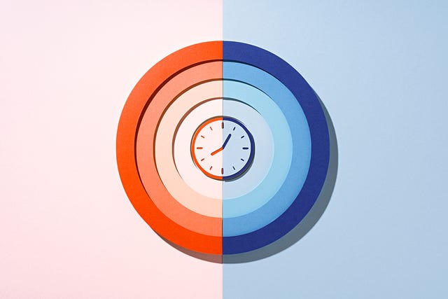 a circular paper clock design divided into warm and cool color halves