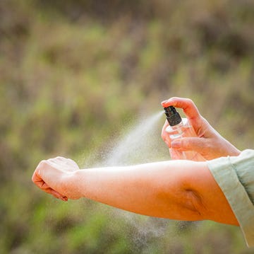Woman spraying mosquito insect repellent on her arm. Protection against insects bites woman spraying mosquito insect repellent on her arm. protection against insects bites