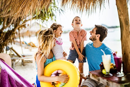 young happy family talking while spending a summer day in a caf eacute on the beach