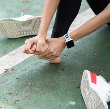 Close-up of Woman Stretching Bare Foot dolore ai piedi, runner, alluce valgo, neuroma di morton