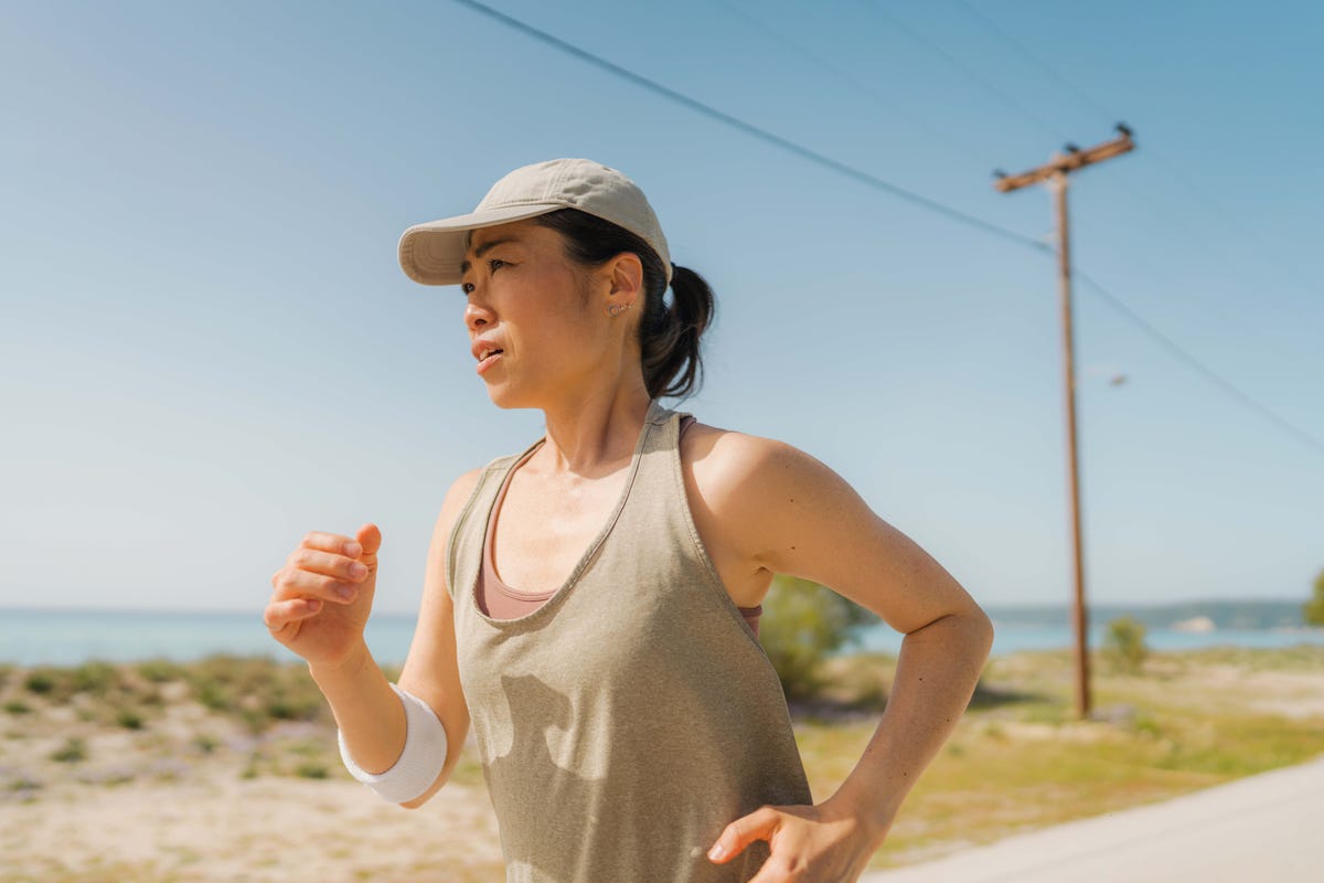 woman in sport's clothing, jogging by the sea