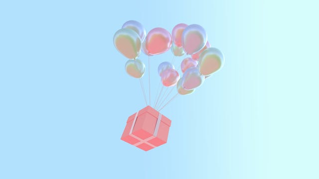 low angle view of balloons and gift box flying against clear sky