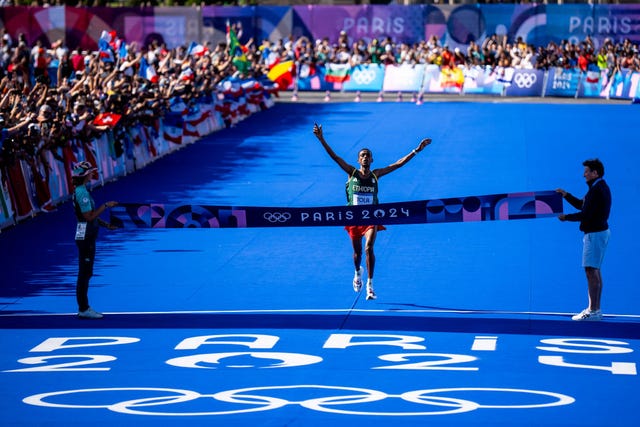 paris, france august 10 tamirat tola of etiopia crosses the finish line to win the gold medal while competing in the mens marathon during day 15 of athletics marathon olympic games paris 2024 at esplanade des invalides on august 10, 2024 in paris, france photo by rene nijhuisbsr agencygetty images