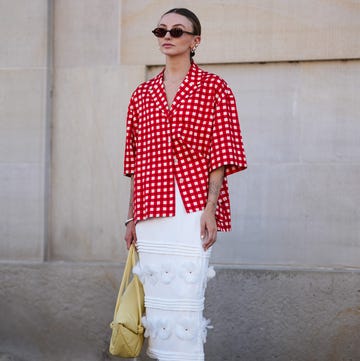 Street Style - Day 2 - Copenhagen Fashion Week SS25 copenhagen, denmark august 6 a guest wears black sunglasses, gold earrings, white and red pattern button up short sleeve shirt, silver bracelet, light yellow leather bag, white midi skirt with floral detail, black flat leather shoes, outside lovechild 1979, during the copenhagen fashion week springsummer 2024 2025 on august 6, 2024 in copenhagen, denmark photo by edward berthelotgetty images