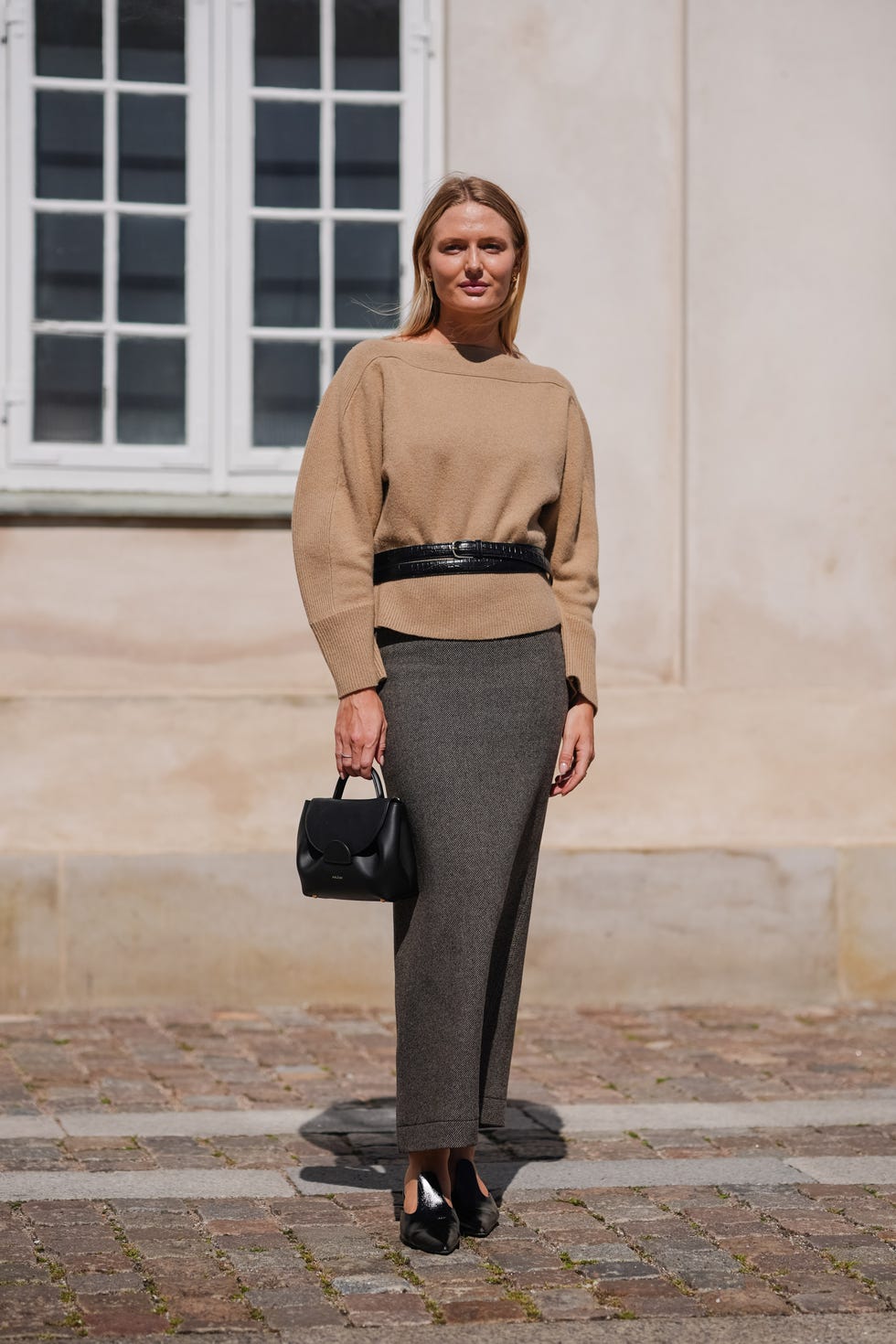 copenhagen, denmark august 6 a guest wears light brown sweater, black leather belt, dark brown maxi skirt, shiny black leather bag, shiny black leather heels, outside lovechild 1979, during the copenhagen fashion week springsummer 2024 2025 on august 6, 2024 in copenhagen, denmark photo by edward berthelotgetty images