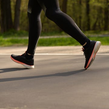 Legs of a person running on a run walking. legs of a person running on on a run walking the man is running sportswear healthy lifestyle wet footprints from shoes on the dry surface of the track
