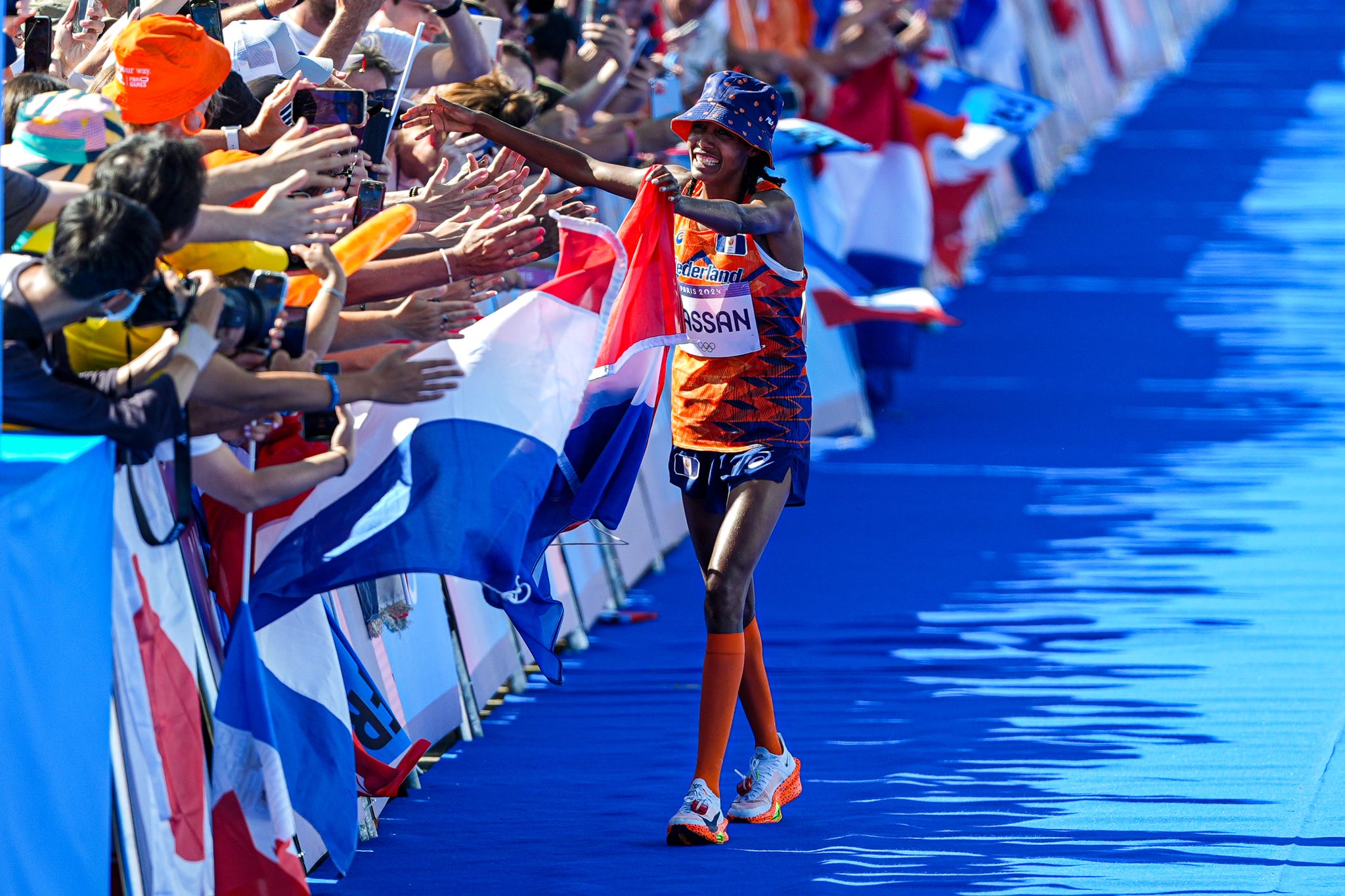paris, france august 11: sifan hassan of the netherlands runs to fans with a dutch flag after competing in the womens marathon during day 16 of athletics marathon olympic games paris 2024 at esplanade des invalides on august 11, 2024 in paris, france. (photo by joris verwijst/bsr agency/getty images)