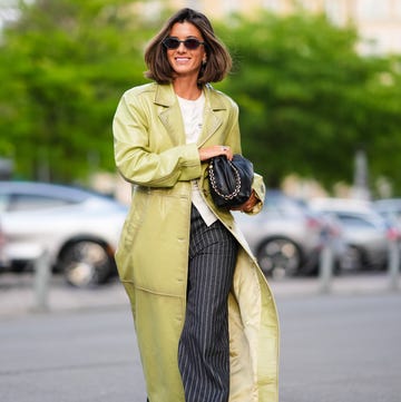 Street Style - Day 3 - Copenhagen Fashion Week SS25 copenhagen, denmark august 7 a guest wears black sunglasses, gold earrings, white shirt, shiny light green leather trench coat, black and white lined pants, shiny black leather bag, outside baum und pferdgarten, during the copenhagen fashion week springsummer 2024 2025 on august 7, 2024 in copenhagen, denmark photo by edward berthelotgetty images