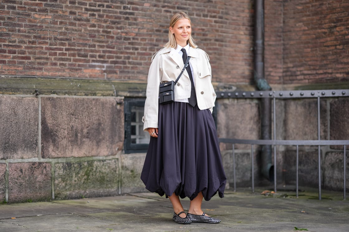 copenhagen, denmark august 7 a guest wears white button up long sleeve shirt, black tie, cream cropped trench coat, black crossbody leather bag, mixed metals rings, black midi skirt, black ballerina flats with silver studded detail, outside mark kenly domino tan, during the copenhagen fashion week springsummer 2024 2025 on august 7, 2024 in copenhagen, denmark photo by edward berthelotgetty images