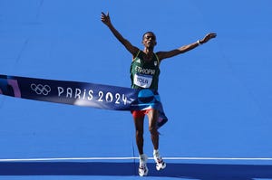 paris, france august 10 tamirat tola of team ethiopia crosses the finish line to win the gold medal during the mens marathon on day fifteen of the olympic games paris 2024 at esplanade des invalides on august 10, 2024 in paris, france photo by hannah petersgetty images