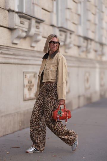 vienna, austria august 26 karin teigl seen wearing andy wolf black sunglasses, by aylin koenig white cotton basic cropped shirt, bershka brown animal printed oversized long pants, zara beige cropped cord jacket, miu miu orange leather arcadie bag with colorful bag charms and adidas silver leather sl 72 og sneakers, on august 26, 2024 in vienna, austria photo by jeremy moellergetty images