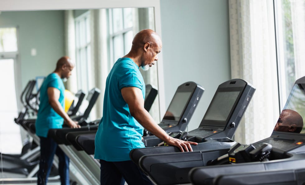 a senior african american man working out at the gym, walking on a treadmill