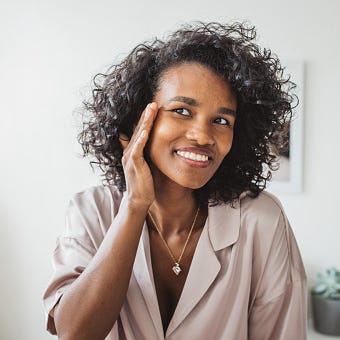 young woman in bathroom applying moisturizing cream on her skin after having a bath young woman in bathroom applying moisturizing cream on her skin after having a bath