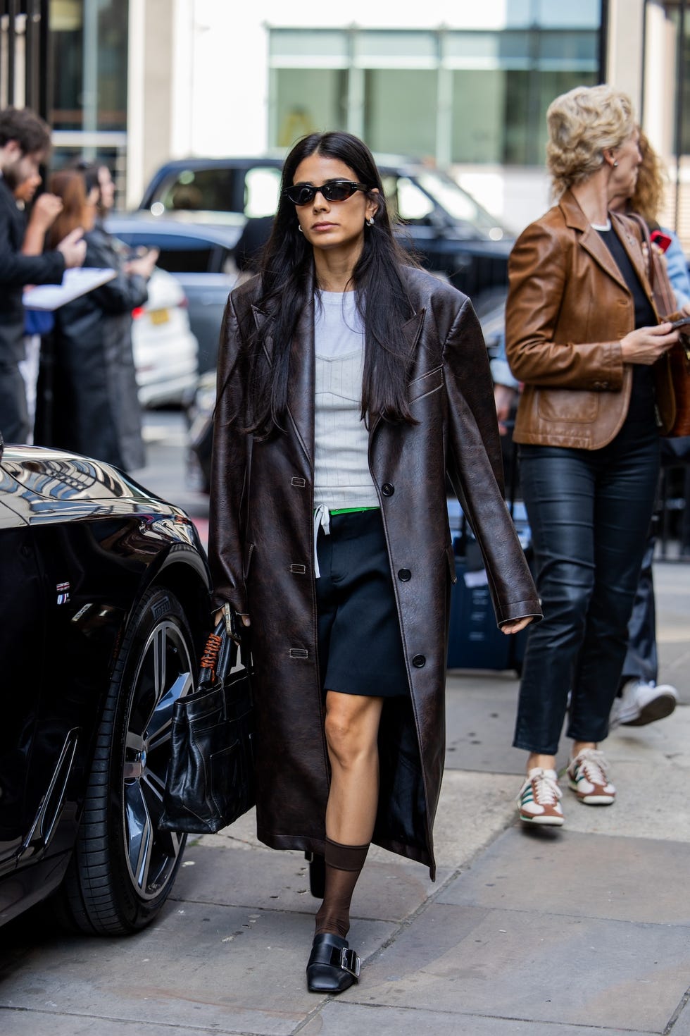 london, england september 15 a guest wears leather coat, bag outside jw anderson during london fashion week september 2024 on september 15, 2024 in london, england photo by christian vieriggetty images