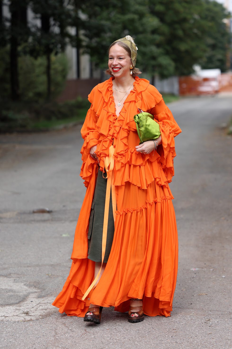 milan, italy september 21 chloe king wears orange long ruffled blouse, olive green midi skirt, brown heels, green satin bag, outside ferragamo, during the milan fashion week menswear springsummer 2025 on september 21, 2024 in milan, italy photo by claudio laveniagetty images