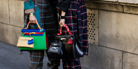 two individuals holding stylish handbags