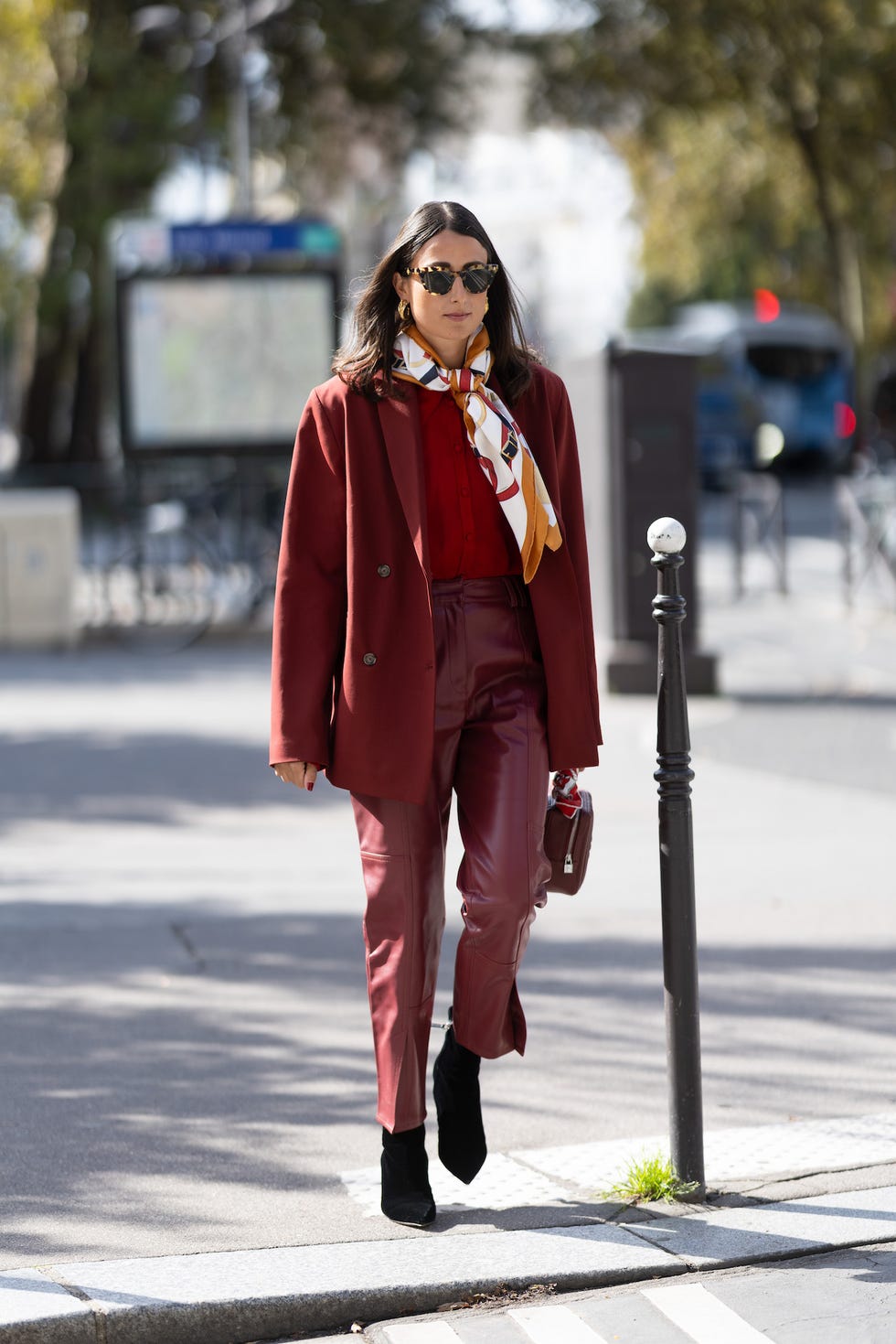 paris, france september 28 a guest wears red leather trousers, a red leather bag, black heeled shoes, brown sunglasses, a red blazer, a red shirt and a colorful printed scarf outside hermes show during womenswear springsummer 2025 as part of paris fashion week on september 28, 2024 in paris, france photo by valentina frugiuelegetty images