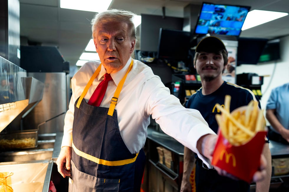 a person handing french fries at a fast food counter