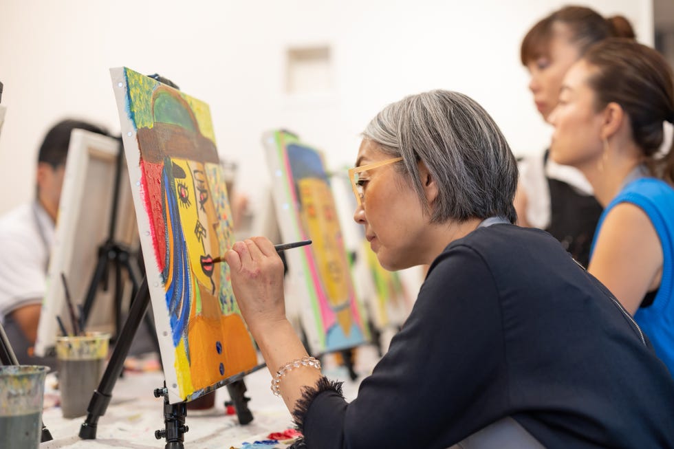 art school participants painting with serious expressions.