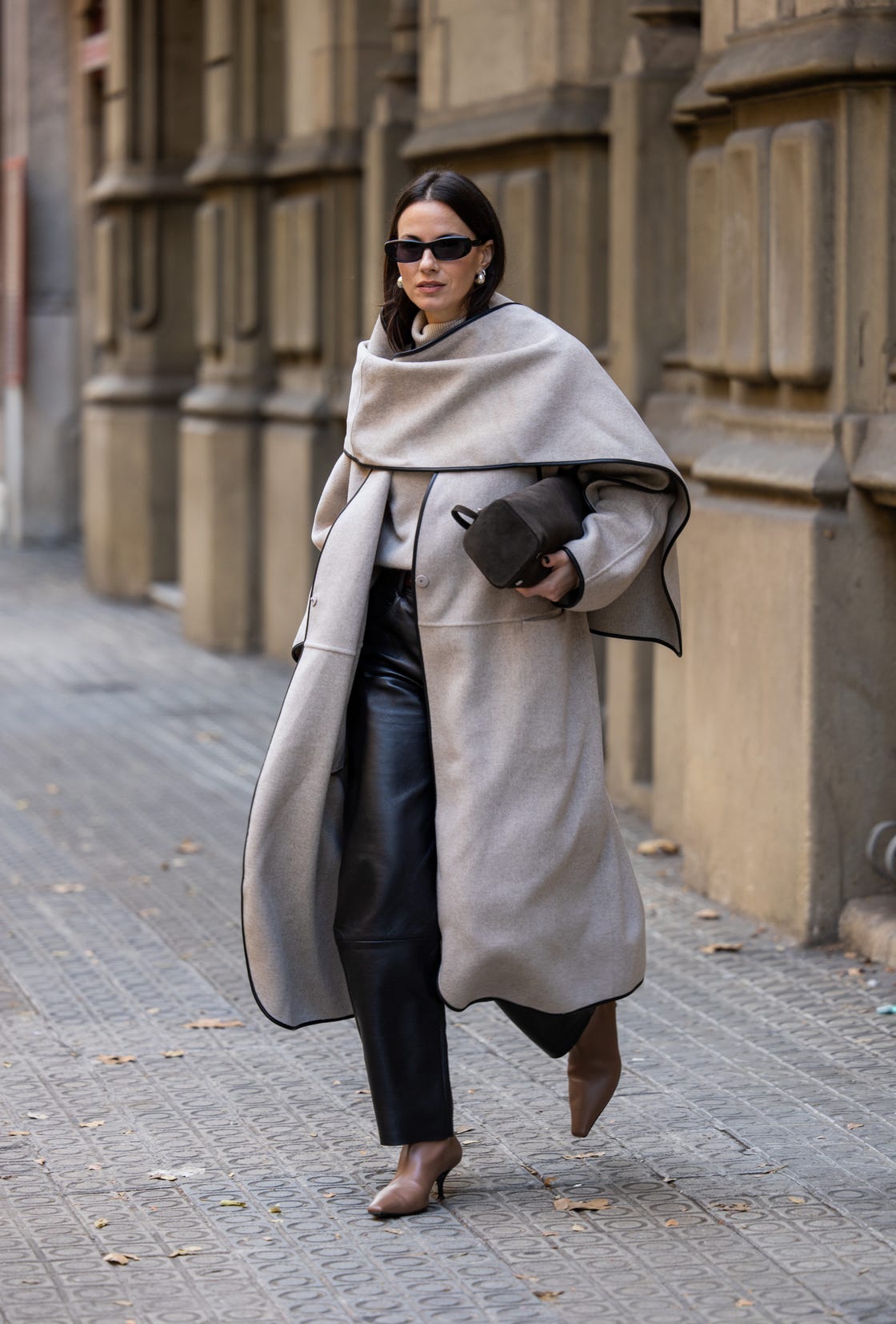 barcelona, spain november 11 zina charkoplia wears brown neous boots, almada sweater, black lamarque leather pants, grey cos coat with cape, podyh bag on november 11, 2024 in barcelona, spain photo by christian vieriggetty images