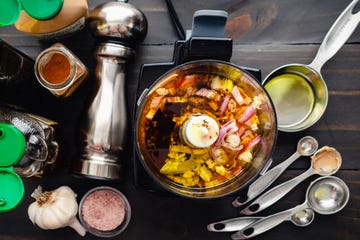 olive oil and vinegar based dressing in a small food processor surrounded with other ingredients