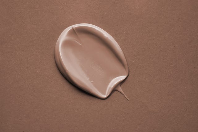 beige cosmetic cream swatch on a mocha color background color of the year 2025
