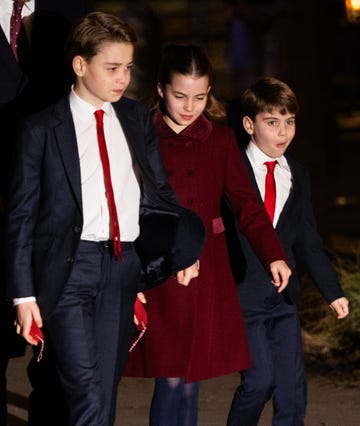 children walking together in formal attire with red accents set in a dimly lit environment