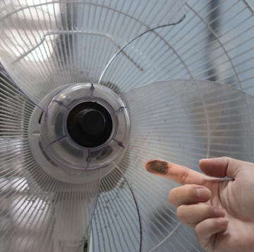 How to clean your fan close up finger hand dirty and dust on floor fan. unhealthy air flow for respiratory system, wipe, rub and wash at least 1 time per month, big cleaning day in home concept. selective focus image.