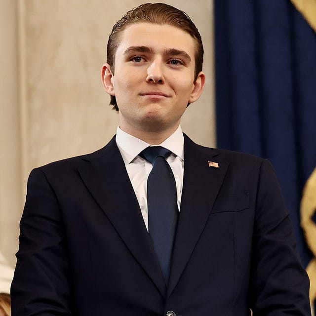 barron trump stands and looks to the left, he wears a suit jacket, white collared shirt, and navy tie, photo by chip somodevillagetty images