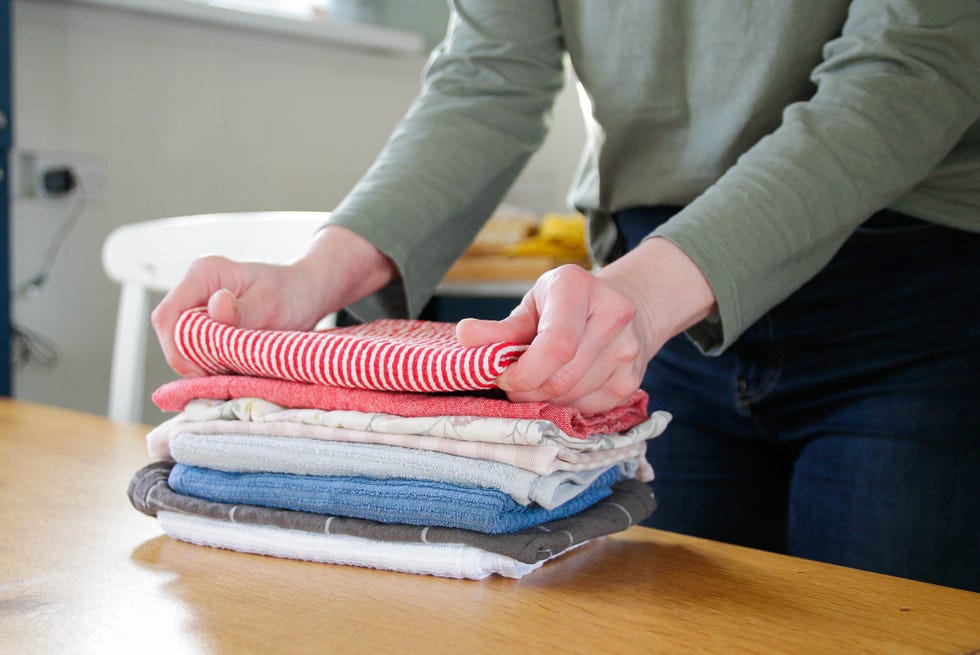 person folds kitchen towels