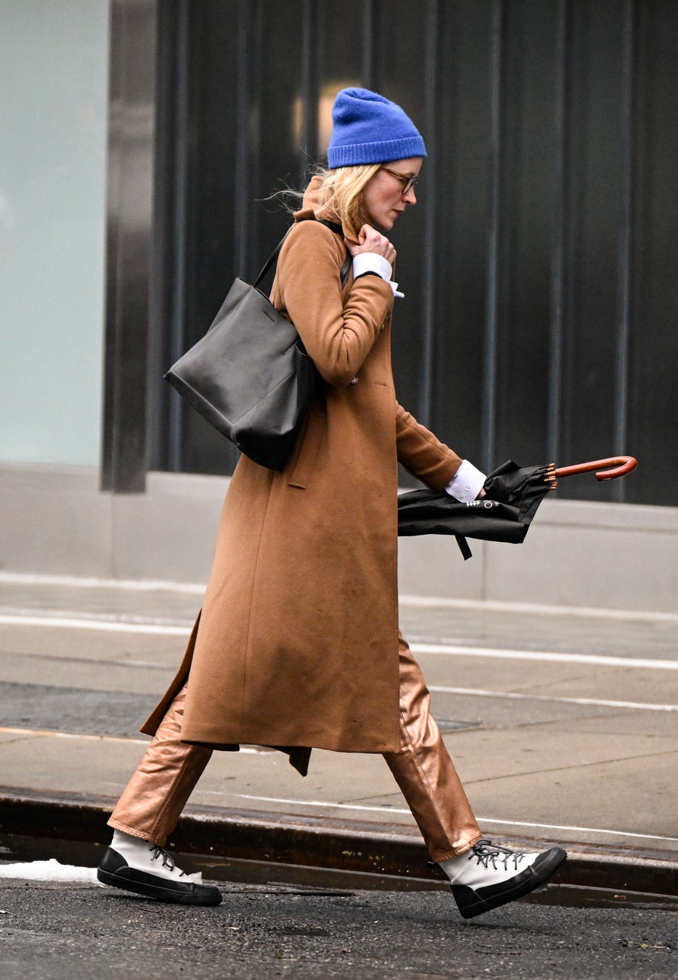 new york, new york february 06: a guest is seen wearing a brown coat, black bag, white boots and blue beanie outside the brandon maxwell show during nyfw f/w 2025 on february 06, 2025 in new york city. (photo by daniel zuchnik/getty images)