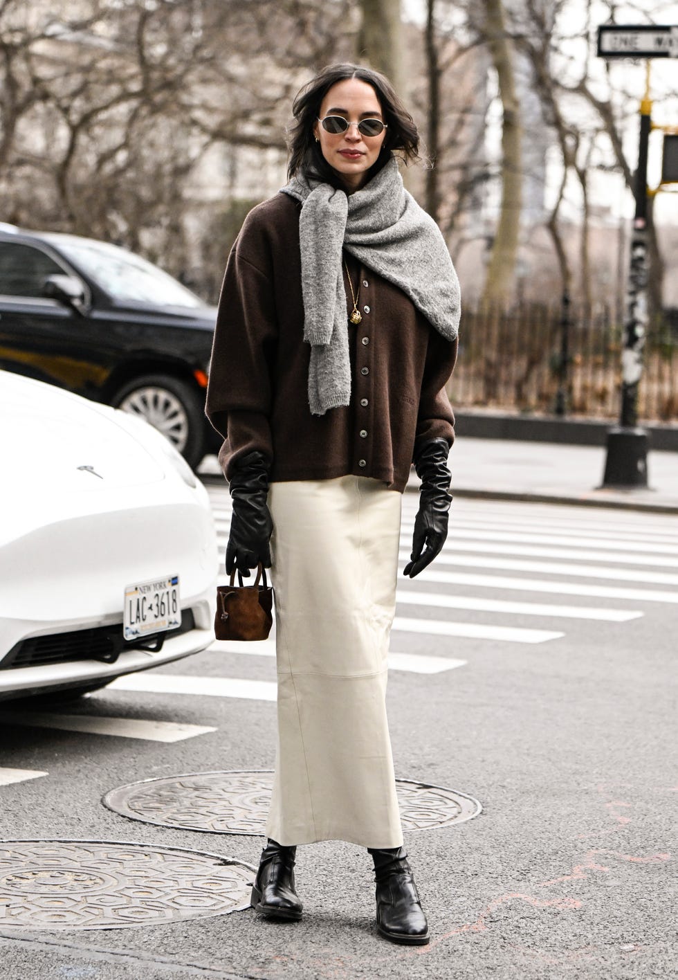 new york, new york february 08 a guest is seen wearing a brown coat, gray sweater, cream skirt and mini bag with black boots outside the altuzarra show during nyfw fw 2025 on february 08, 2025 in new york city photo by daniel zuchnikgetty images