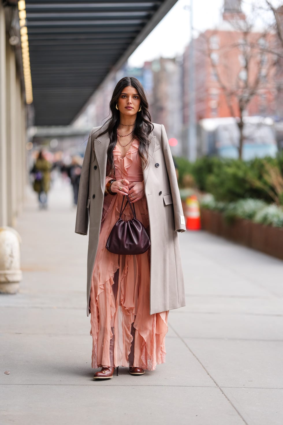 new york, new york february 08 a guest wears silver earrings, black layered necklaces, light brown oversized blazer coat, light pink ruffled midi dress, shiny dark brown boots leather shoes, outside alice  olivia, during the new york fashion week fallwinter 2025 on february 8, 2025 in new york, new york photo by edward berthelotgetty images