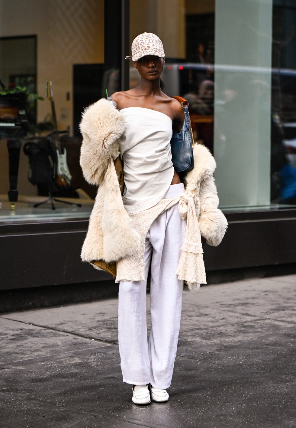 new york, new york february 09 a model is seen wearing a cream fur coat, cream top and white pants, blue and tan bag, gold cuff, white shoes and animal print hat outside the lapointe show during nyfw fw 2025 on february 09, 2025 in new york city photo by daniel zuchnikgetty images