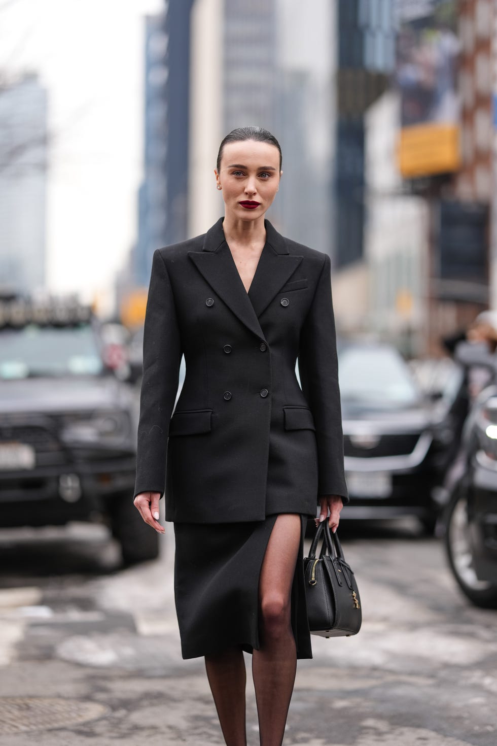 new york, new york february 11: mary leest wears black oversized tailored michael kors blazer jacket, black high slit michael kors over the knee skirt, shiny black michael kors leather bag, black sheer mesh tights, outside michael kors, during the new york fashion week fall/winter 2025 on february 11, 2025 in new york, new york. (photo by edward berthelot/getty images)