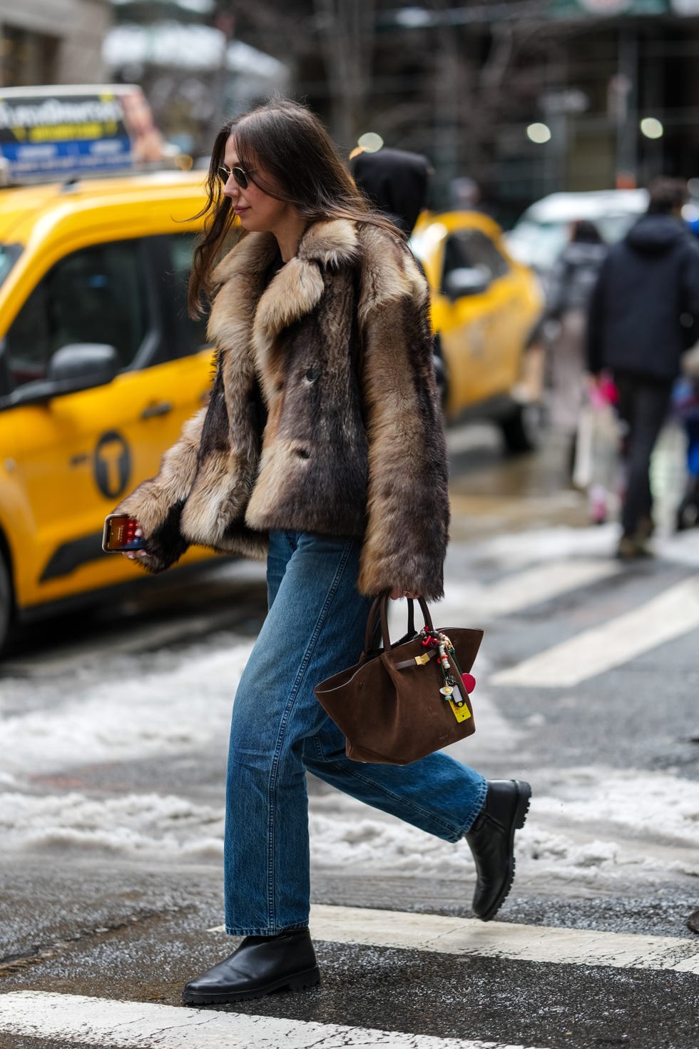 new york, new york february 09 a guest wears a brown faux fur coat, blue denim pants jeans , a brown suede demellier bag, black leather shoes, outside sandy liang, during new york fashion week, on february 09, 2025 in new york city photo by edward berthelotgetty images