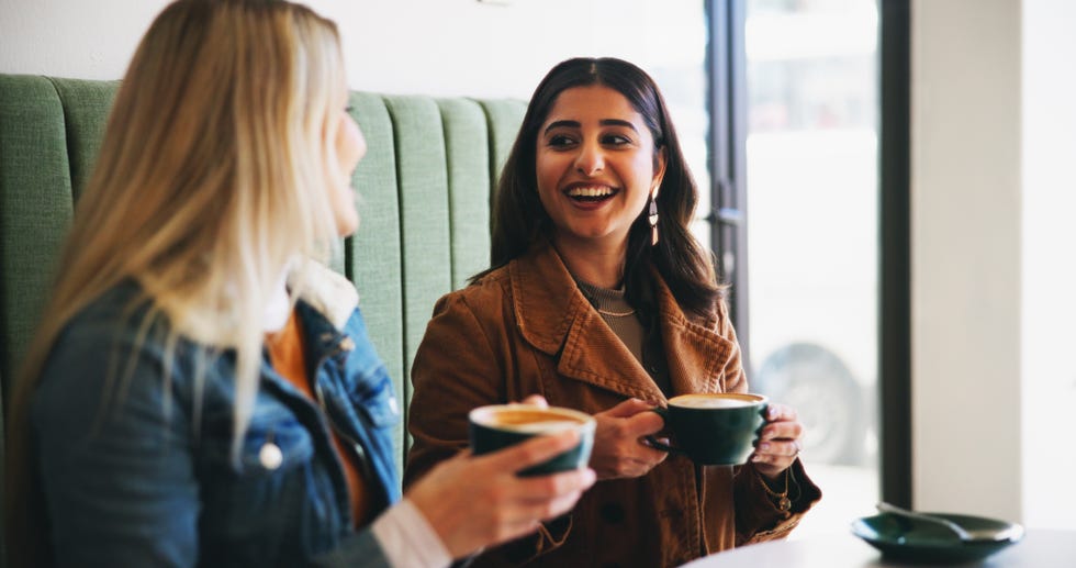 women, friends and laugh with drink at coffee shop with conversation, memory and funny joke for bonding. girl, people and relax with talk, cappuccino and listening with chat, gossip or story at cafe